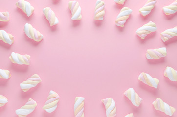 a frame of pastel color marshmallow on pink background with copy space