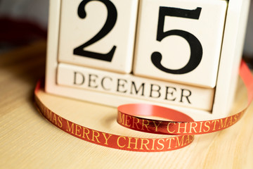 December 25th date on calendar with merry christmas greeting on ribbon