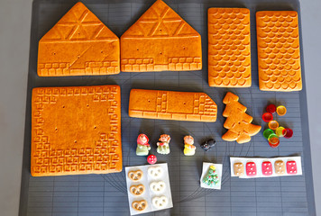 Parts of gingerbread house prepared for baking and decorating. Christmas traditional activity and sweet cake. Active fun for family and kids. Close-up of details.