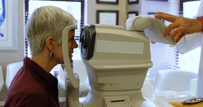 Optometrist examining patient eyes with autorefractors 4k
