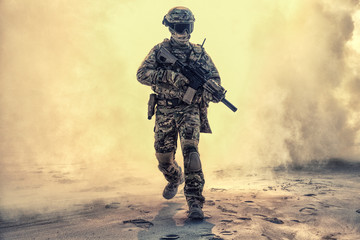 Army soldier in military camouflage uniform, helmet, with face hiding behind mask and glasses,...