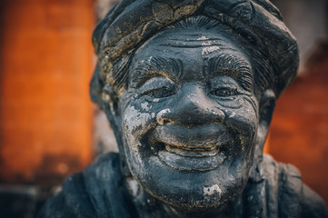 Closeup portrait of Hindu Buddhist traditional stone sculpture. Bali, Indonesia