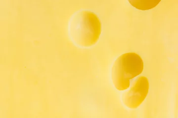 Crédence de cuisine en verre imprimé Produits laitiers Food background. Surface of fresh Maasdam cheese with holes creamy texture bright yellow color. Template for dairy product advertisement poster with copy space for text