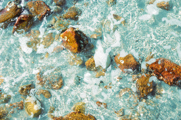 stone under clear water of the sea with small bubble from sea wave