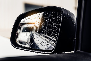 Raindrops on car rear view mirror.