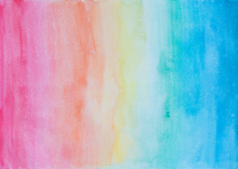 Abstract hand painted watercolor background in rainbow colors with watercolour stains and paper texture.