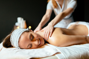 Obraz na płótnie Canvas Beautiful young and cute woman enjoying massage treatment