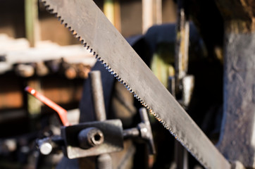The band saw machine cutting raw metals rods. The industrial saw