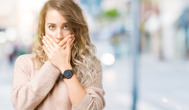Beautiful young blonde woman wearing sweatershirt over isolated background shocked covering mouth with hands for mistake. Secret concept.