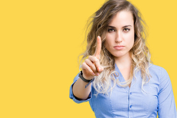 Beautiful young blonde business woman over isolated background Pointing with finger up and angry expression