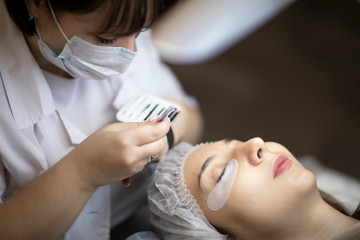 Eyelash extension procedure . Master and a client in a beauty salon