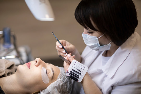 Eyelash extension procedure . Master and a client in a beauty salon