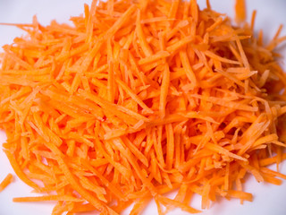 grated fresh carrots on white plate