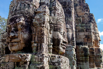 Ancient temple name Bayon with stone faces in Angkor Thom, Siem Reap, Cambodia. Bayon's most distinctive feature is the multitude of serene and smiling stone faces on the many towers.