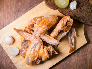  roasted chicken with a crispy crust lies on a dessert table with pickled cucumber, bread