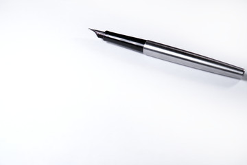 On a blank sheet of paper lies an ink handle .