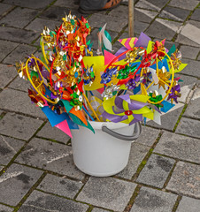 Bunte Spielzeug Windräder in einem Eimer zum Verkauf