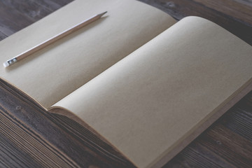 book blank with pen on wood background. Top view.Vintage style.