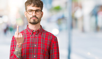 Young handsome man wearing glasses over isolated background Showing middle finger, impolite and...