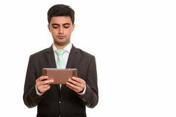 Young handsome Persian businessman holding digital tablet