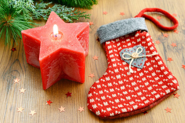 Christmas sock with burning red candle.