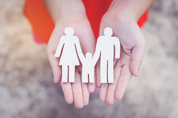 Children hands holding small model family , concept family