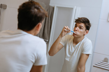 teenager brushing teeth in bathroom