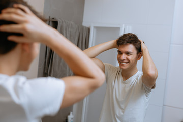 teenager making his hair in bathroom