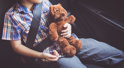 happy little girl wearing seatbelts in car - Powered by Adobe