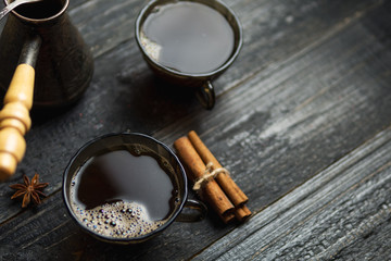 Turkish coffee freshly brewed with cinnamon on a dark wooden table