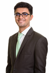 Young happy Persian businessman smiling and looking at camera