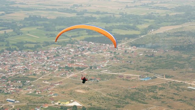 para glider flying an oragne parachute