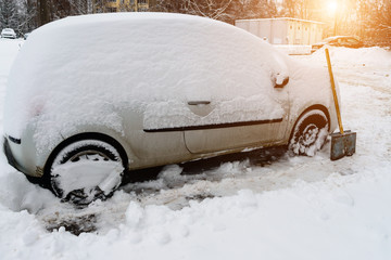 cleaning the car from snow in winter after a snowstorm