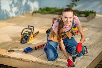 Beautiful girl is engaged in construction using tools