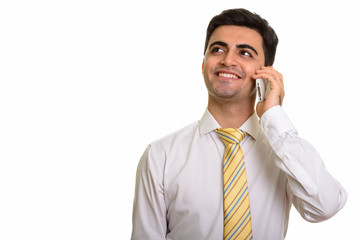 Young happy Persian businessman talking on mobile phone while th