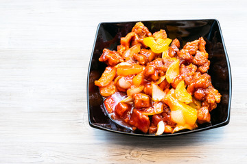sweet and sour Pork on gray table with copyspace