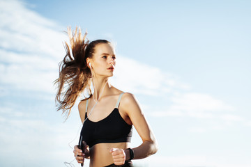Naklejka premium Early morning workout. Happy Beautiful women running in the headphones. Living healthy lifestyle.