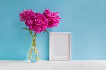 Mockup with a white frame and pink peonies in a vase