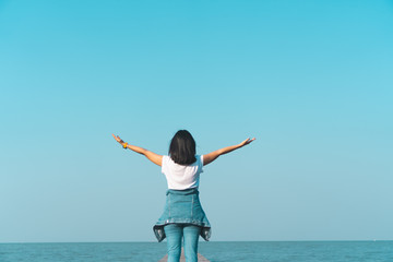 Woman rise hands up to sky freedom concept with blue sky.