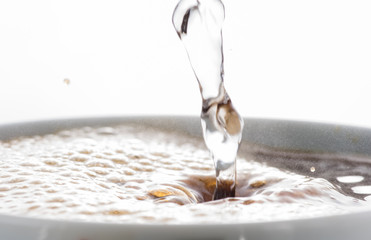 Preparation of instant coffee in a white mug on a white and black background