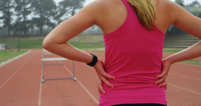 Female athlete standing on a race track 4k