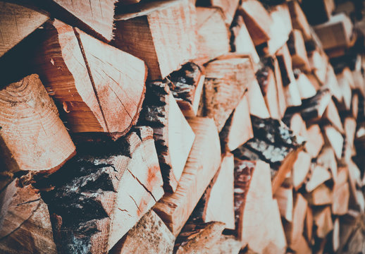 Chopped firewood on a stack, prepared for winter. Photo depicts a backdrop with birch firewood in a pile, hipster filter mood. Natural wooden background.