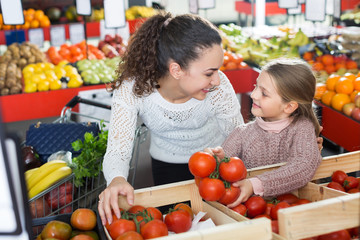 Woman and girl buying tomatoes
