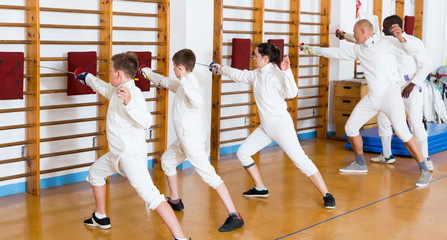 Adult teenages fencers practicing technique on cushions