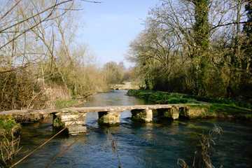 The ancient clapper bridge at Eastleach in spring sunshine in the Cotswolds, Gloucestershire, UK