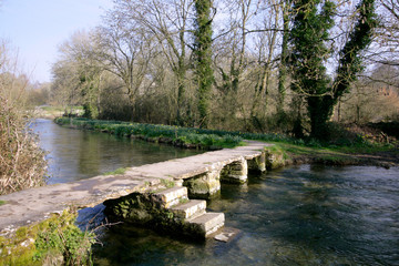 The ancient clapper bridge at Eastleach in spring sunshine in the Cotswolds, Gloucestershire, UK