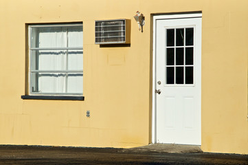 View of door and window to old abandoned roadside office in Bonita Springs Florida in bright sunshine.
