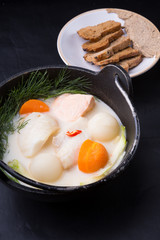 White creamy fish soup served in a metal pot