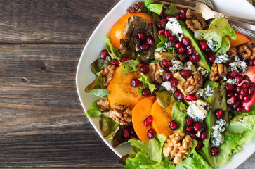 Autumn salad with persimmon, pomegranate, blue cheese and walnuts