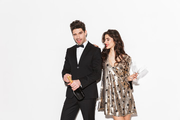 Cheerful smartly dressed couple standing isolated